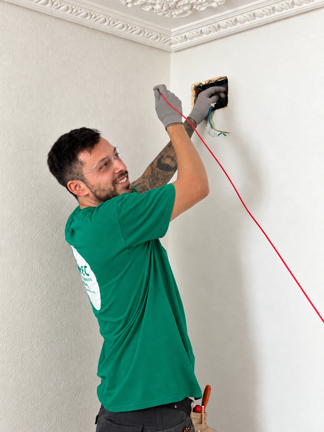 A member of the A.BEC team working on electrical wiring inside a home.